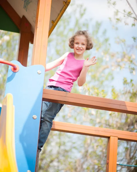 Ung flicka klättring på lekplats — Stockfoto