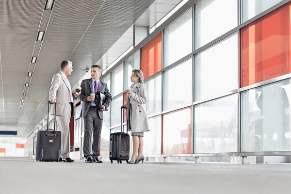 Businesspeople with luggage talking — Stock Photo, Image