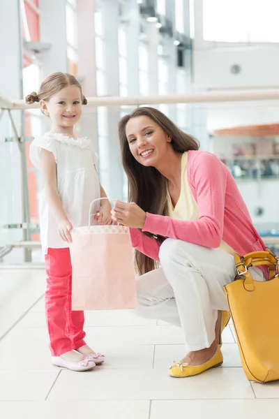 Madre dando hija bolsa de compras — Foto de Stock
