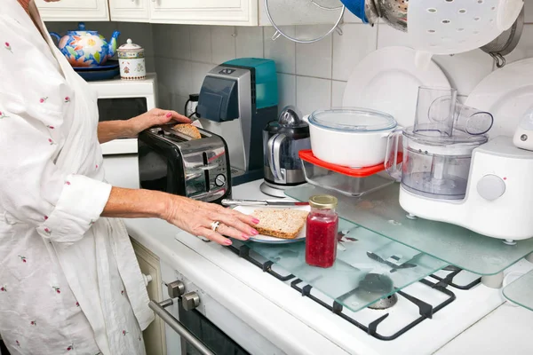 Donna anziana preparare il pane tostato — Foto Stock