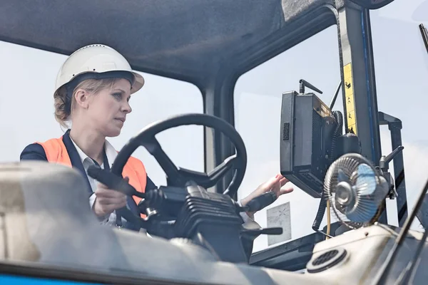 Travailleur féminin opérant chariot élévateur — Photo