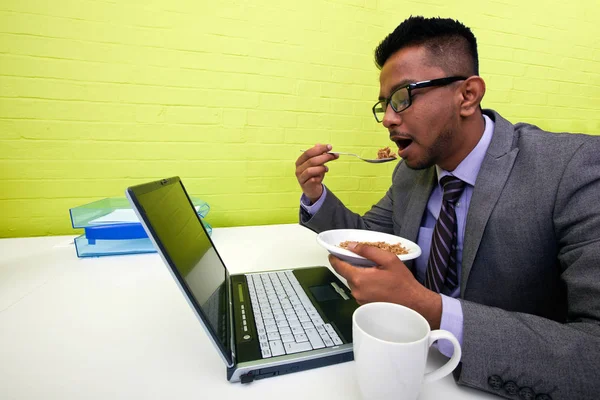 Hombre comiendo en el escritorio — Foto de Stock