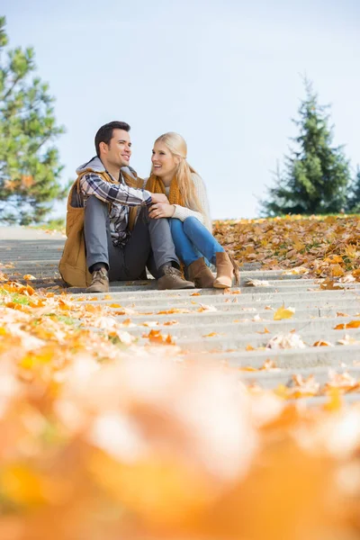 Couple sitting on steps in park — Stock Photo, Image