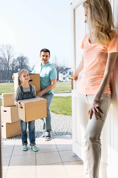 Woman looking at family with boxes — Stock Photo, Image