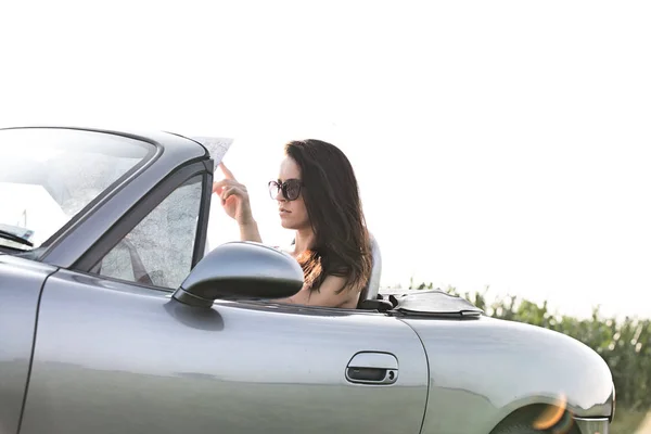 Mujer leyendo mapa en convertible —  Fotos de Stock