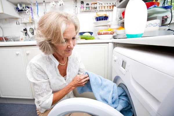 Senior mulher carregando máquina de lavar roupa — Fotografia de Stock