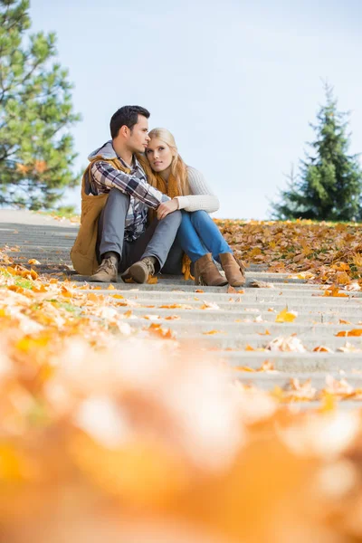 Paret sitter på stegen i park — Stockfoto