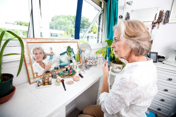 Senior woman combing hair — Stock Photo, Image