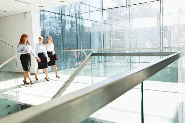 Geschäftsfrauen gehen auf Büroflur — Stockfoto