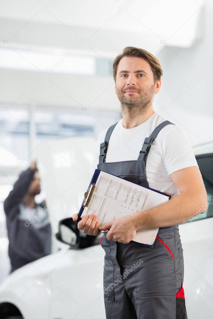 automobile mechanic with clipboard 