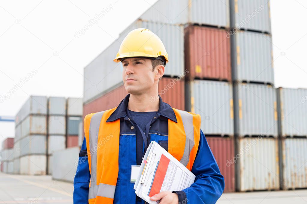 Man with clipboard in shipping yard