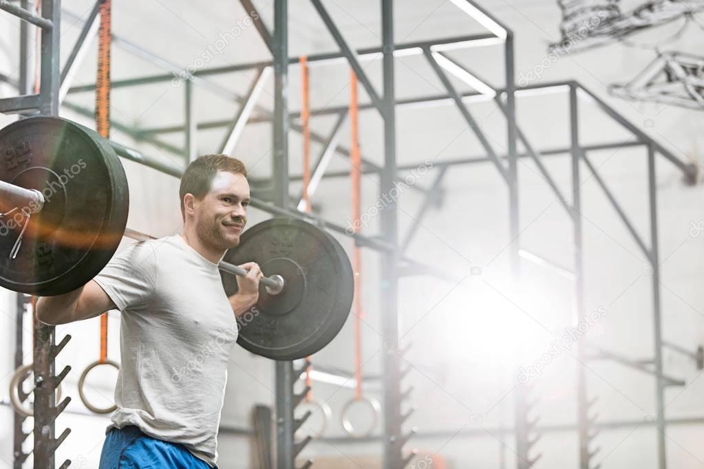 man lifting barbell at crossfit gym