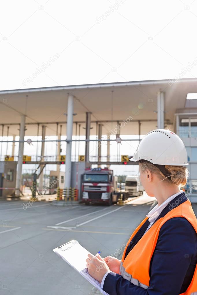 Female worker writing on clipboard