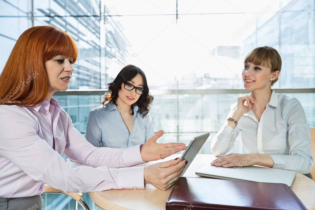 Businesswomen discussing over tablet PC