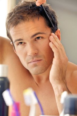 Adam saçını tarıyor.