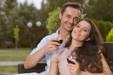 Mutlu çift kırmızı şarap alıyor