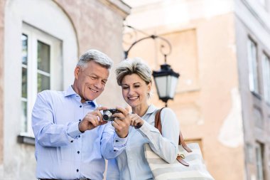 Fotoğraflara bakarken mutlu bir orta yaşlı çift 