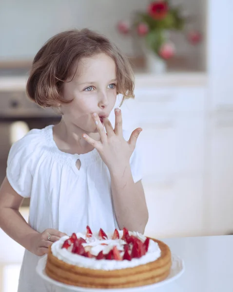 Meisje met cake en aardbeien — Stockfoto