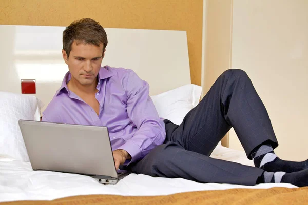 Homme utilisant un ordinateur portable sur le lit — Photo