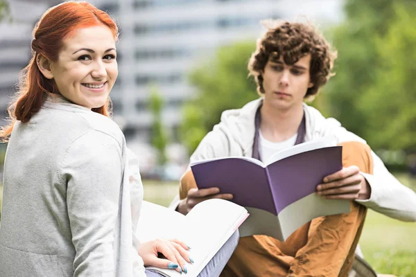 Молодая женщина с другом-мужчиной учится — стоковое фото