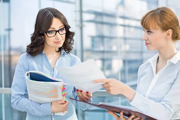 Businesswoman showing document to colleague — Stock Photo, Image