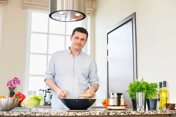 Selbstbewusster Mann bereitet Essen zu — Stockfoto