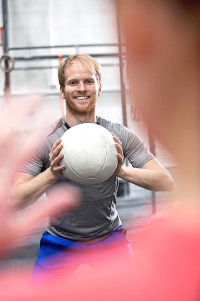 Mann wirft Ball in Richtung Frau — Stockfoto