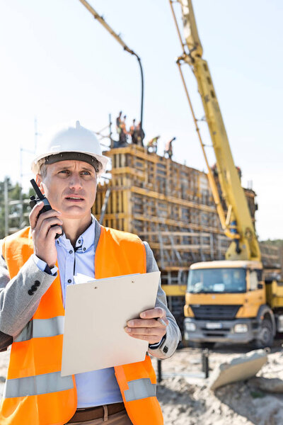 Male supervisor using walkie-talkie 