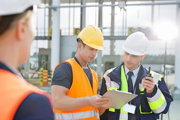 Trabajadores discutiendo sobre portapapeles — Foto de Stock