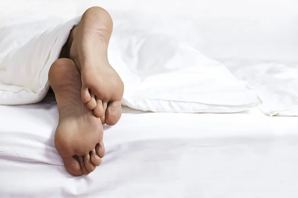 Osoby nohy v posteli — Stock fotografie