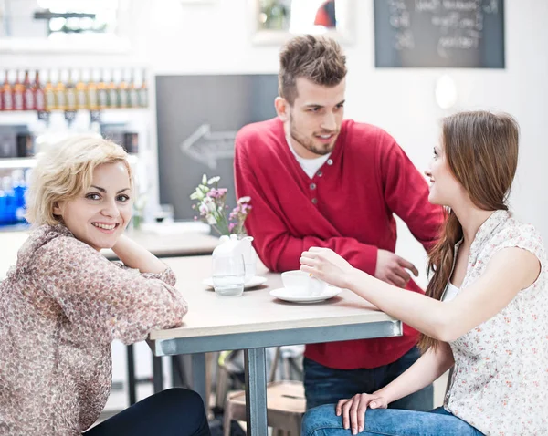 Lachende vrouw met vrienden bij café — Stockfoto