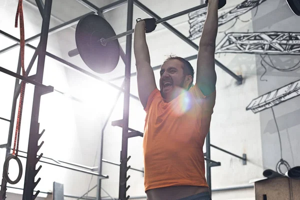 Hombre levantando barra en crossfit gimnasio — Foto de Stock