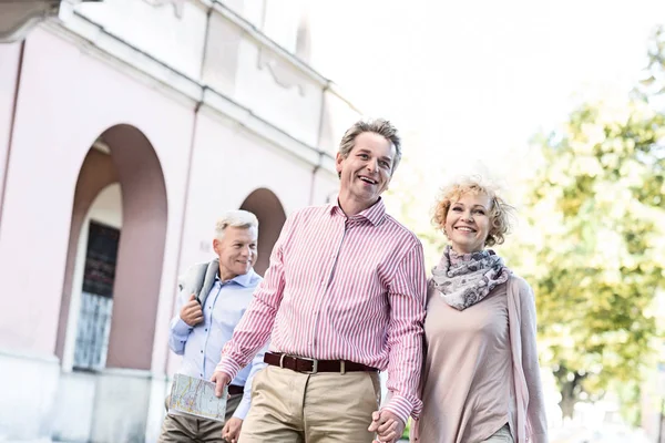 Feliz pareja de mediana edad con mapa caminando — Foto de Stock