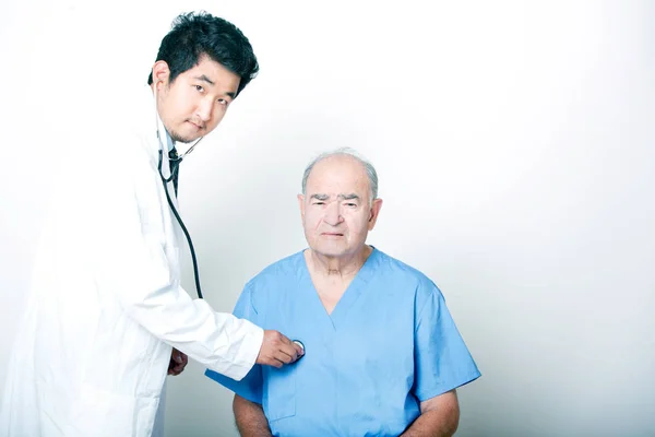 Азиатский врач утешает пожилого пациента — стоковое фото