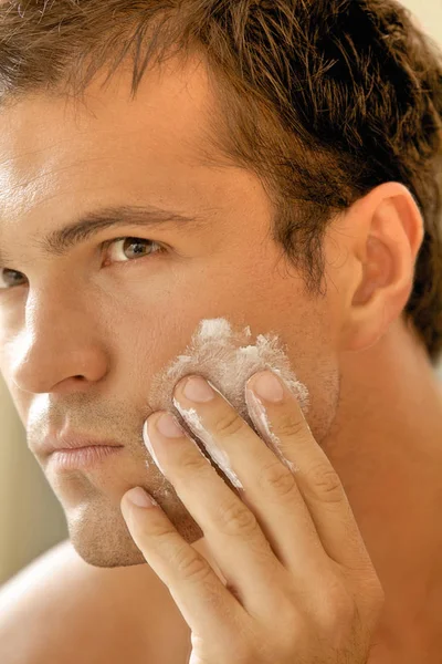 Hombre aplicando crema de afeitar — Foto de Stock