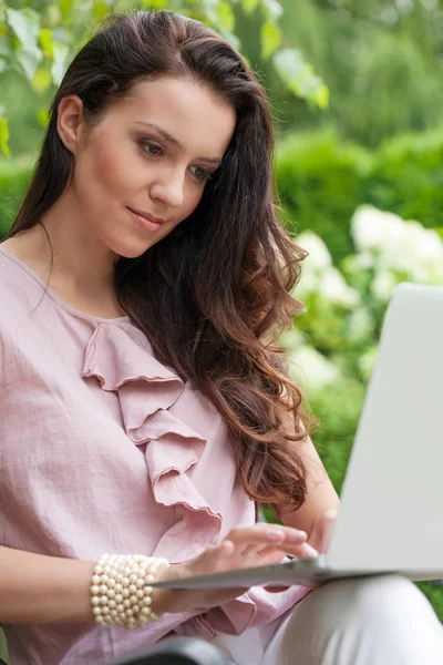 Žena přes notebook v parku — Stock fotografie