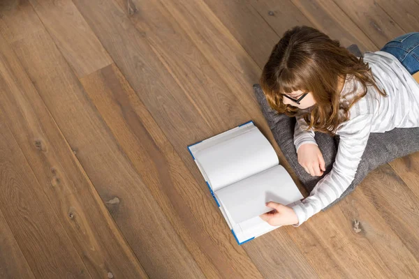 Mädchen liest Buch auf dem Boden — Stockfoto