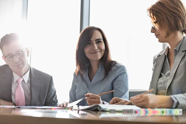 Smiling businesswoman with colleagues — Stock Photo, Image