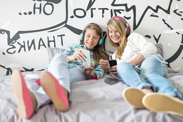 Relaxed sisters listening to music — Stock Photo, Image