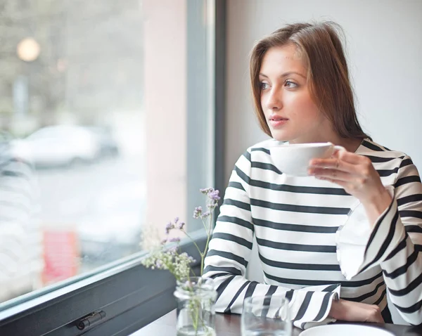 Une jeune femme réfléchie qui boit du café — Photo