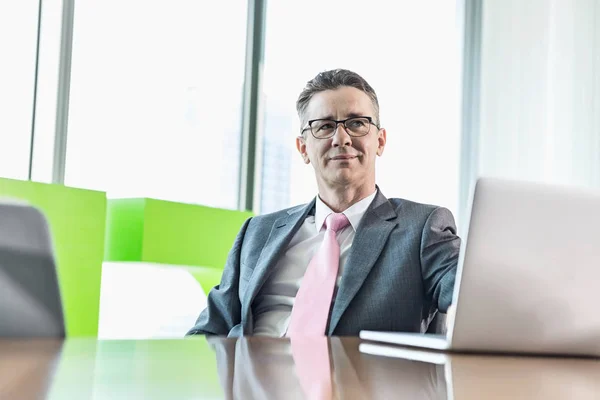 Zakenman met laptop op conferentietafel — Stockfoto