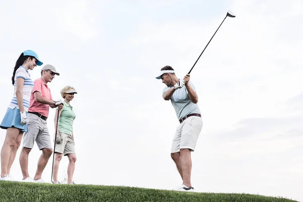 Vrienden op zoek naar man golfen — Stockfoto