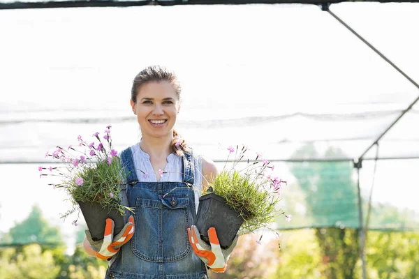 Jardineiro segurando plantas em vaso — Fotografia de Stock