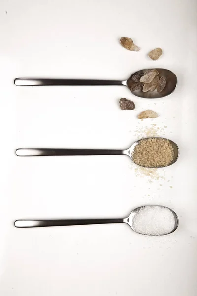 Коричневый, белый и натуральный сахар на ложках — стоковое фото