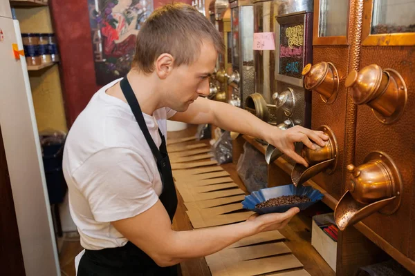 Vendedor dispensando grãos de café — Fotografia de Stock