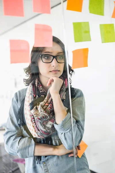 Creative businesswoman reading sticky notes — Stock Photo, Image