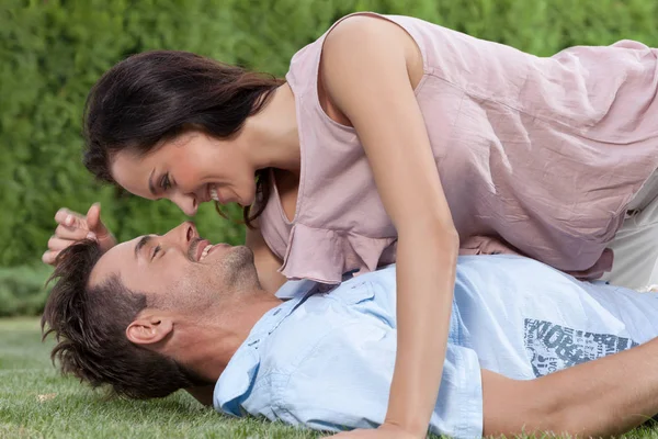 Woman lying on man in park — Stock Photo, Image