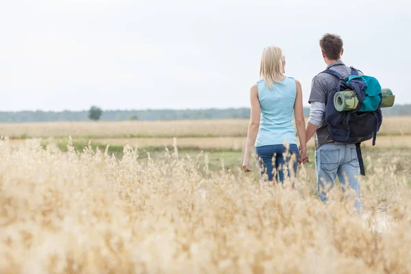 Couple marchant à travers le champ — Photo