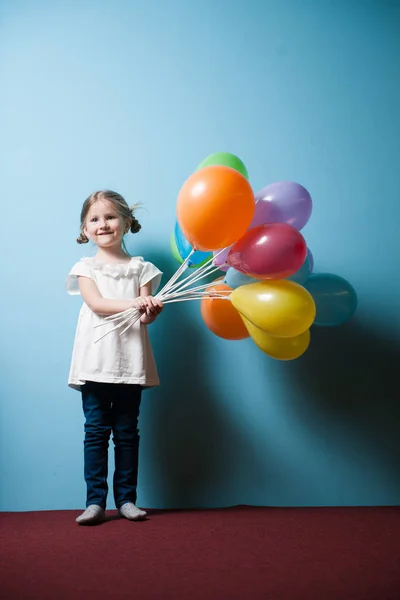 Girl holding bunch of balloons — Stock Photo, Image