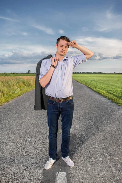 man standing on empty rural road